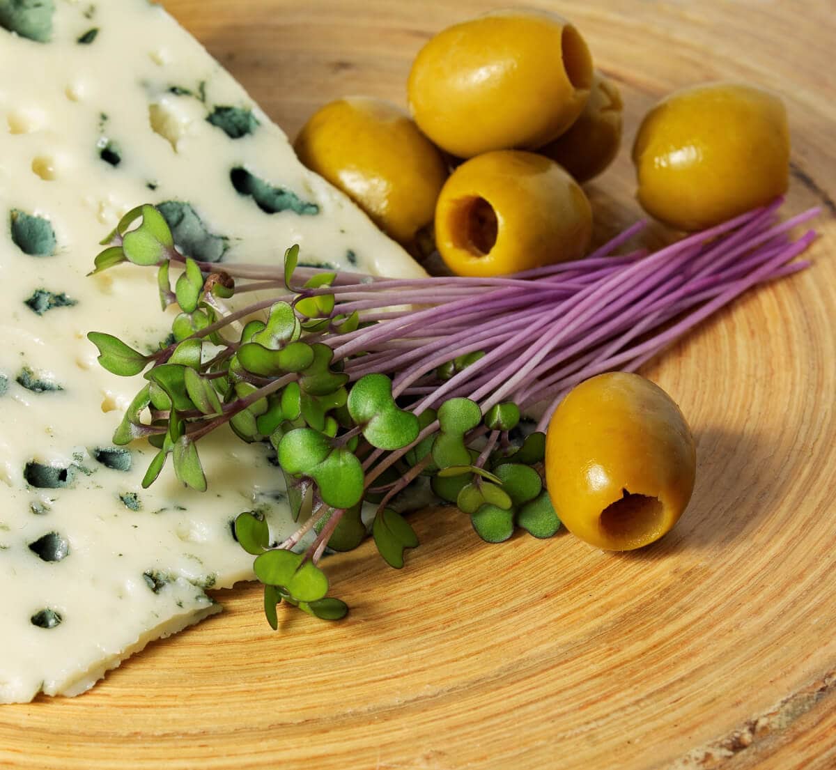 Mikroliście czerwonej kapusty z serem i oliwkami na desce